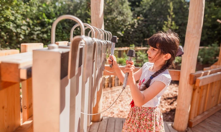 Young girl playing with the giant chimes