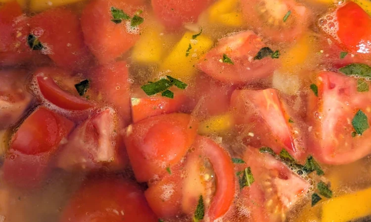 Squash and tomatoes simmering in vegetable stock