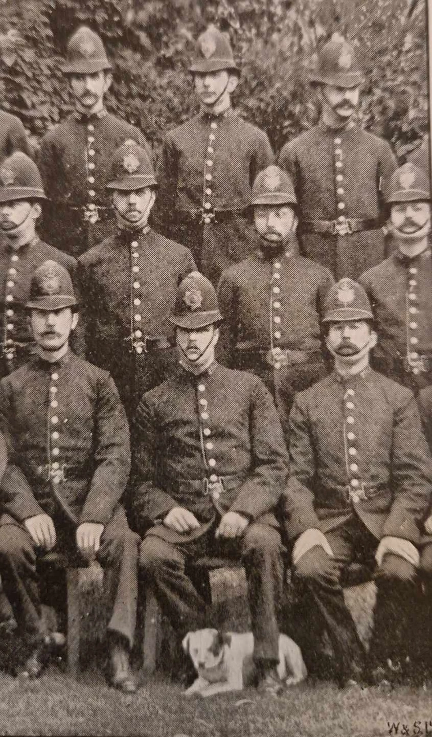 Topper, a dog belonging to the Hyde Park Police Station, posing with his colleagues