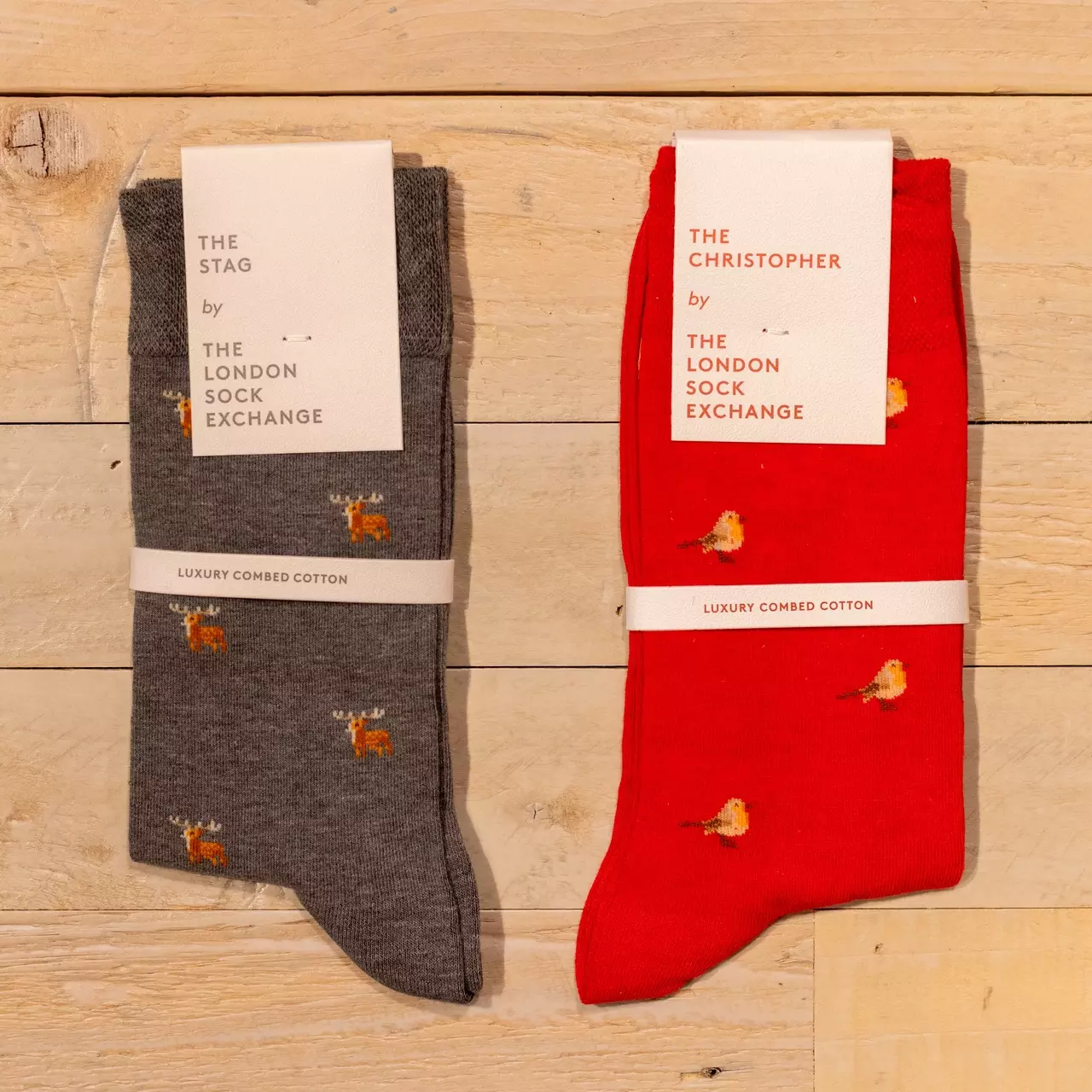 A pair of red socks with robins on and grey socks with stags on from the London Sock Exchange