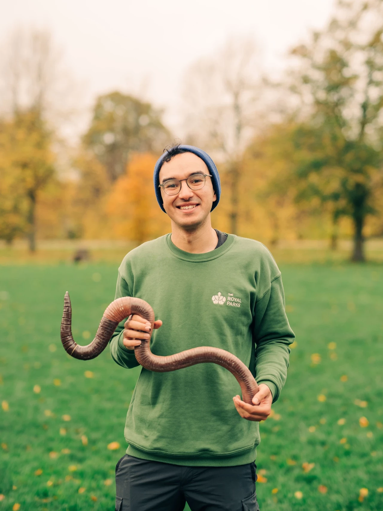 Member of staff holding giant model of giant earthworm