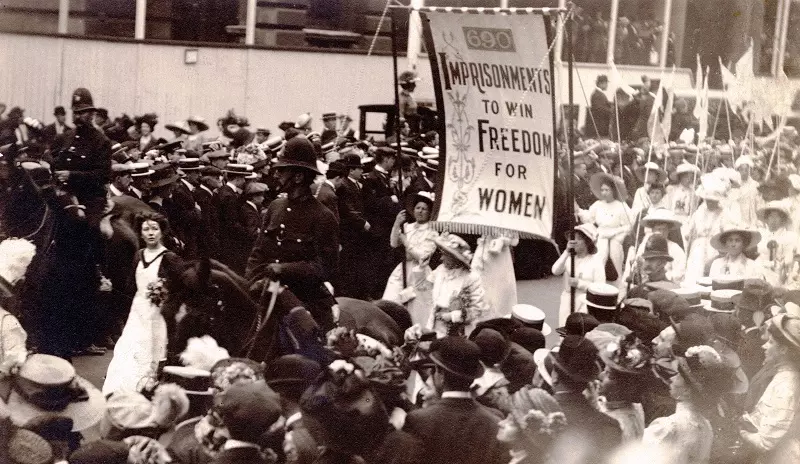 Suffragettes protesting on a crowded street