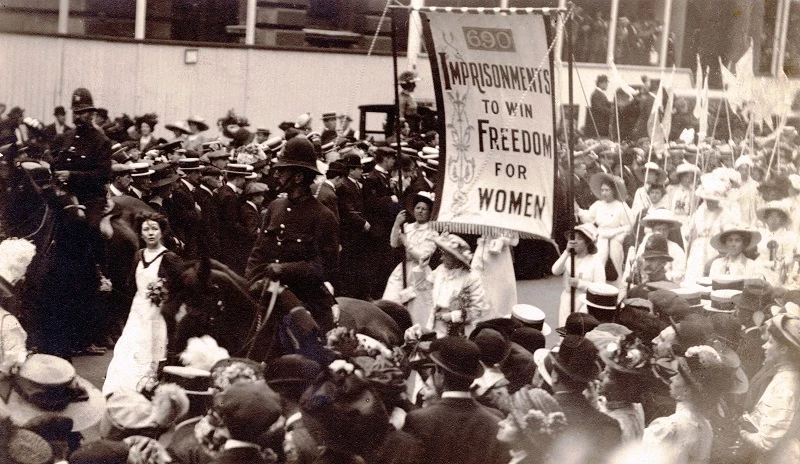 Suffragettes protesting on a crowded street