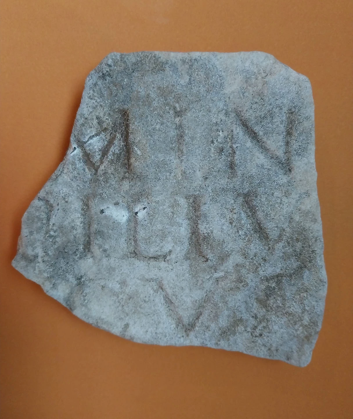 A fragment of marble with the visible remnants of an inscription - just a few letters can be identified
