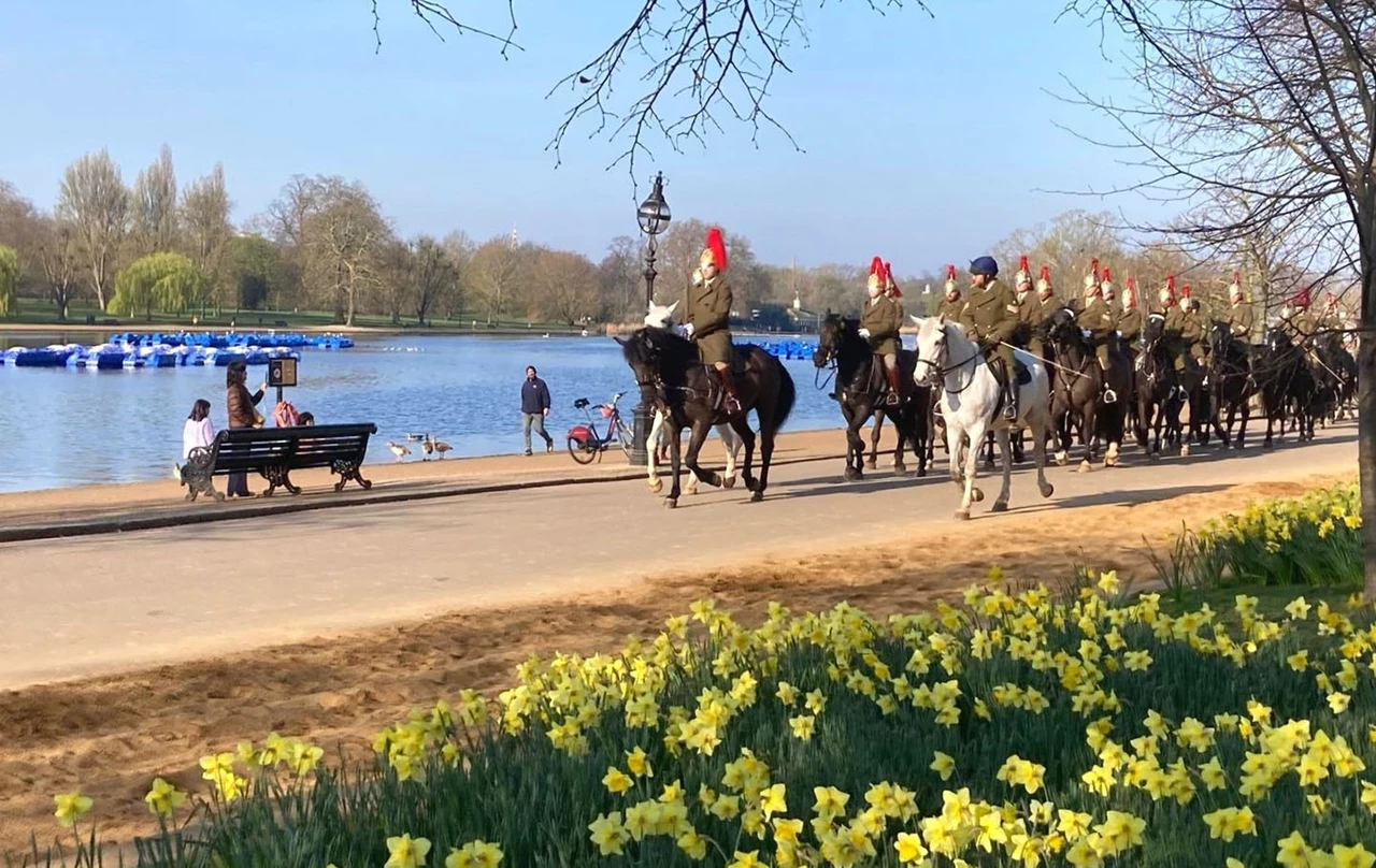 Soldiers on horseback riding alongside the Serpentine lake