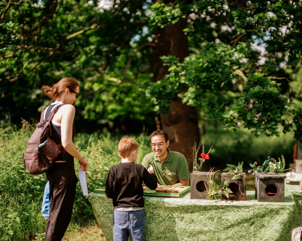 A mother and child playing a nature game at a table with a member of staff