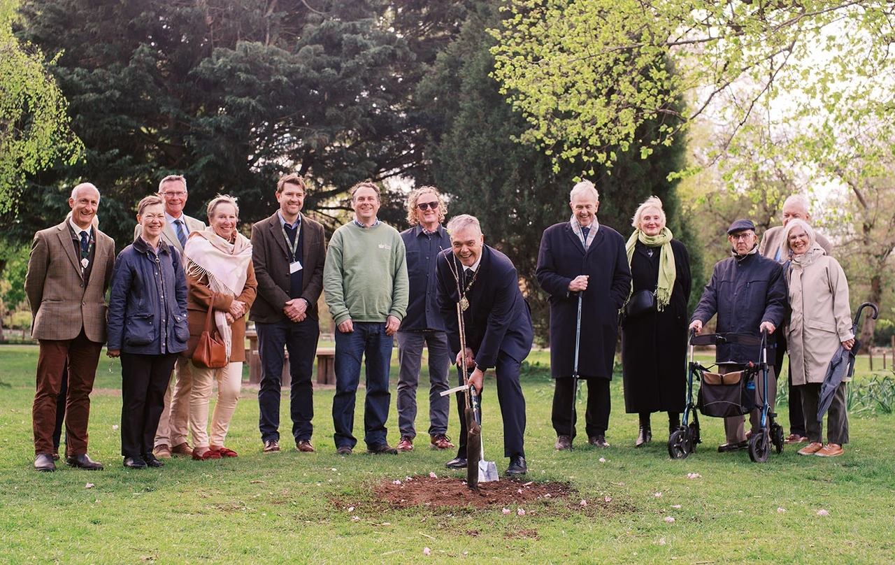 A group of adults (The Worshipful Company of Fruiterers and TRP staff) gather to plant a ceremonial tree