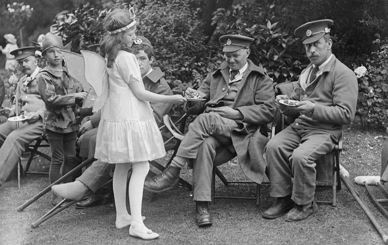 Girl in a fairy costume waits on convalescing First World War soldiers