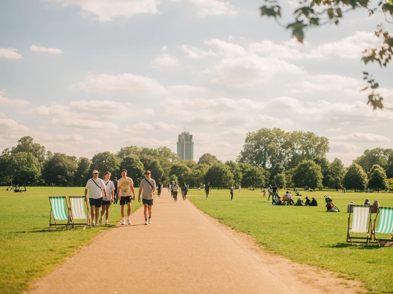 Image of people walking on a path that across a lush, green park.