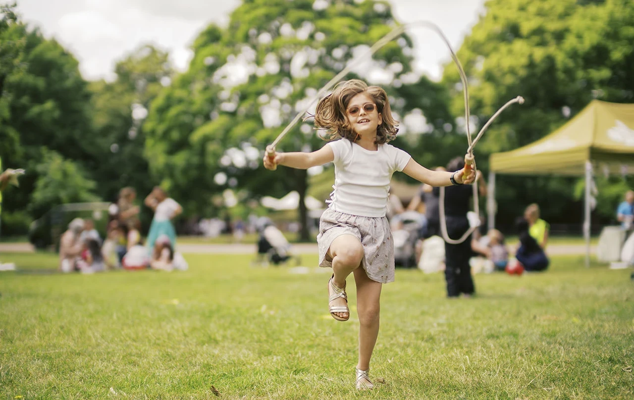 Girl skipping with a rope on the grass
