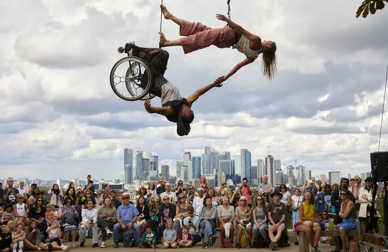 Image of circus performers on cycles against the backdrop of Greenwich Park.