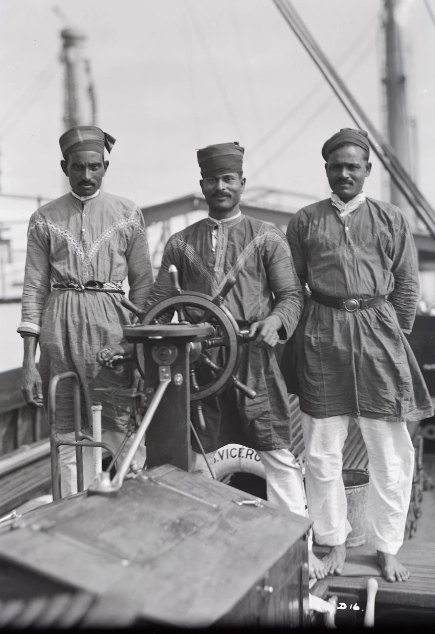 Black and white photo of 3 lascar sailors aboard a ship in 1929.