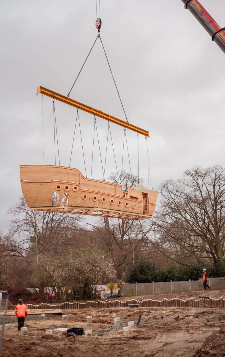 The wooden play galleon is carefully lowered into place by crane