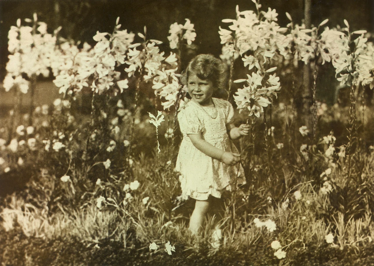 Princess Elizabeth picking flowers in a photograph taken by her father, King George VI.