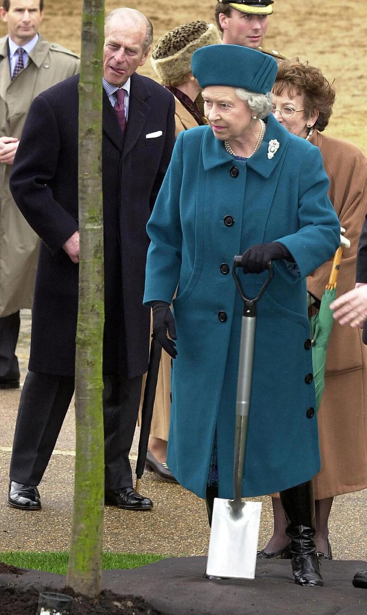 Queen Elizabeth II (accompanied by Prince Philip) plants a chestnut tree in Rotten Row, 18 March 2002