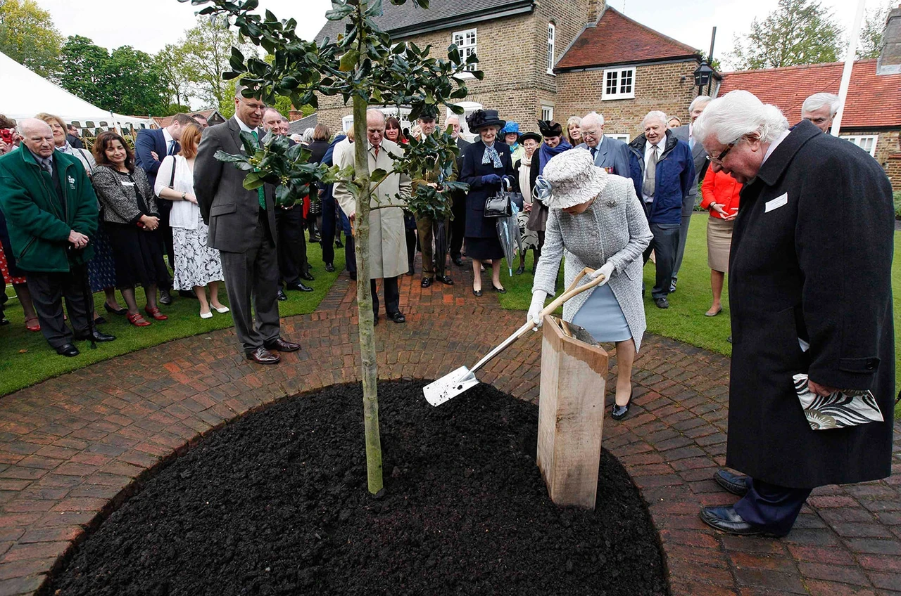 Queen Elizabeth II plants a tree during a visit to Holly Lodge