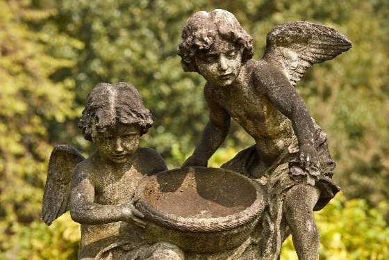 Statute of two angels with a shallow bowl in between