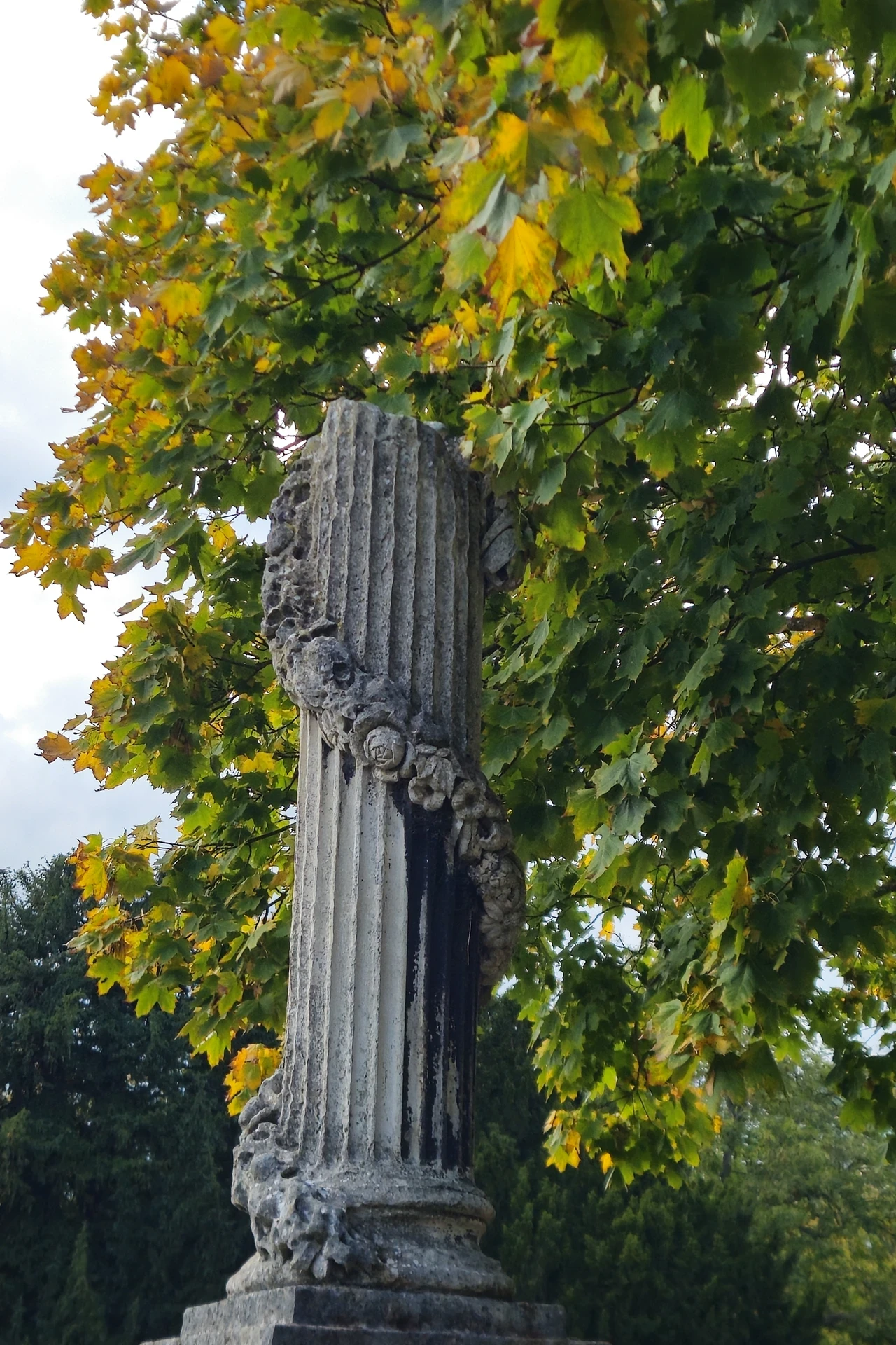 close up image of a stone column with a wreath circling up it